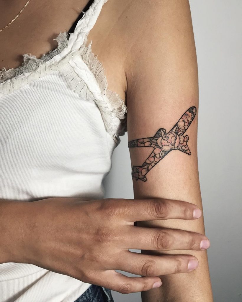 Floral airplane tattoo on the upper arm