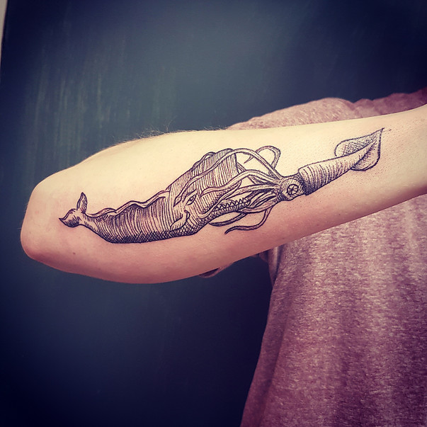 Giant squid and whale tattoo on the forearm