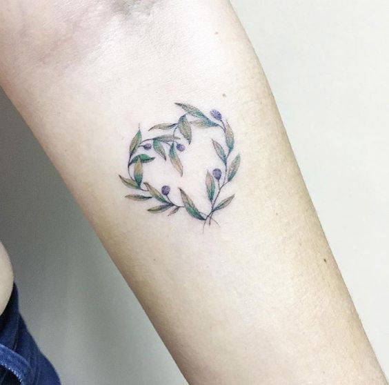 Heart shaped olive branch tattoo on the inner forearm