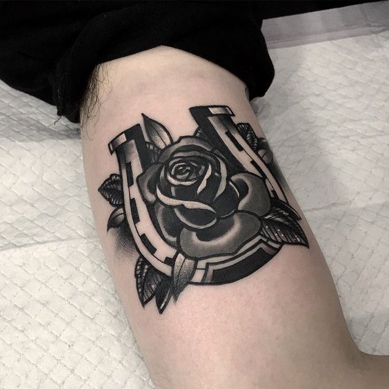 Intense black horseshoe with a rose tattoo