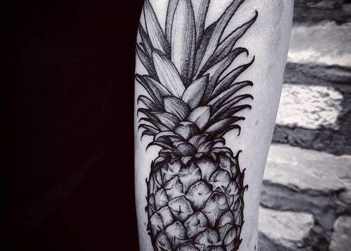 Large hyper realistic pineapple tattoo on the back of the right arm
