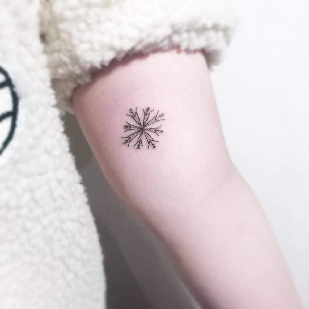 Little snowflake tattoo on the bicep