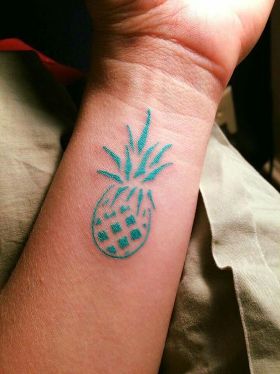 Little teal colored pineapple tattoo on the inner wrist