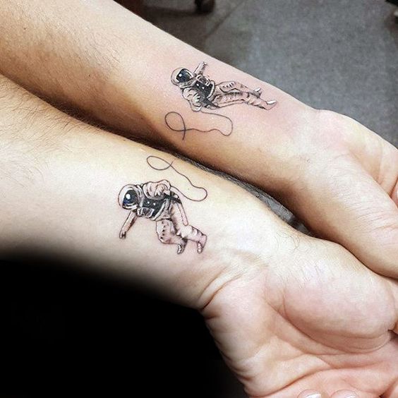 Matching astronaut tattoos on wrists for best friends