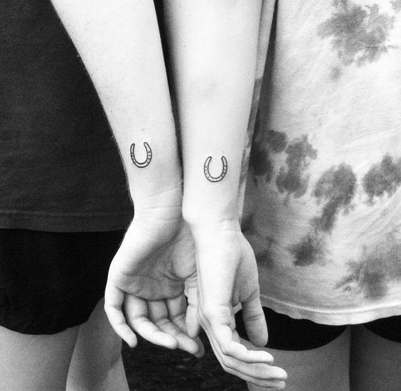 Matching horseshoe tattoos on the wrists for best friends