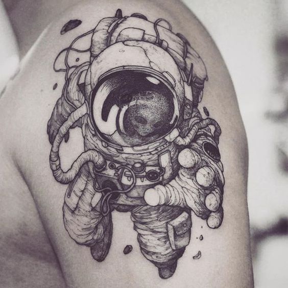 Monochrome cosmonaut tattoo on the left shoulder