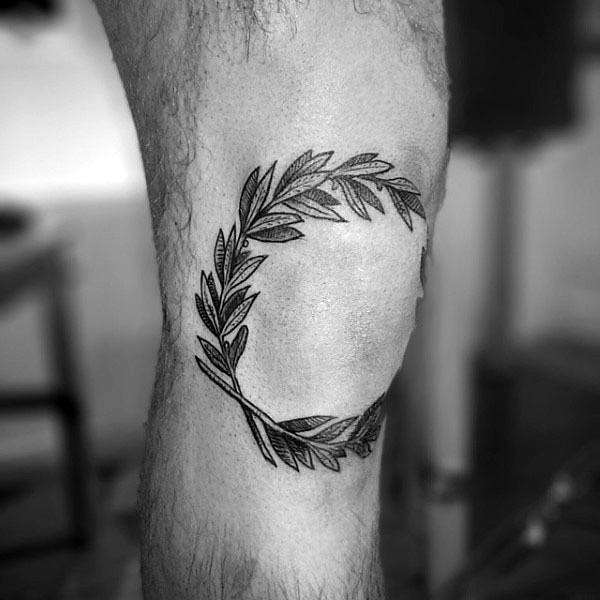 Olive branch wreath tattoo around the knee