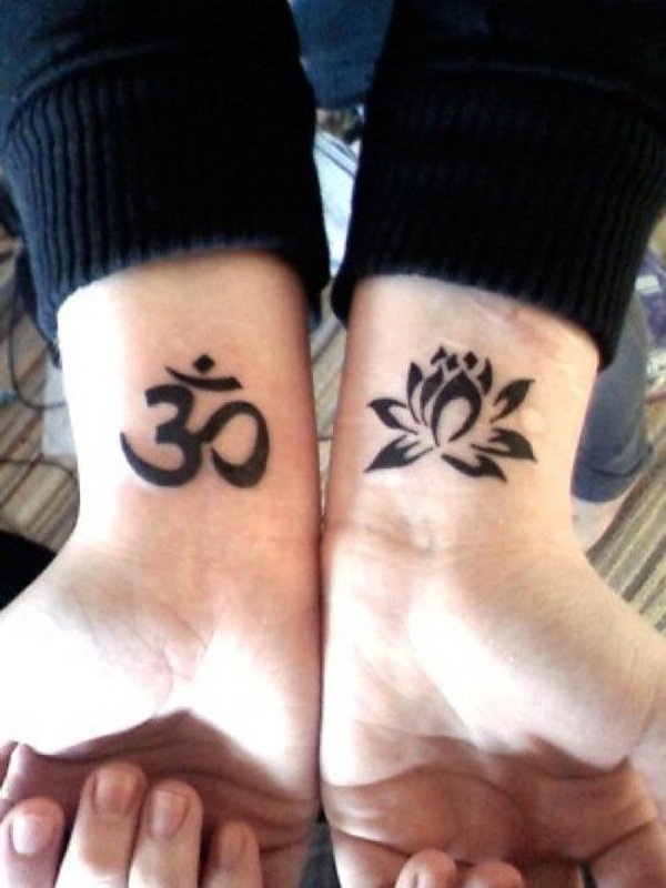 Pure black om and lotus flower tattoos on the wrists
