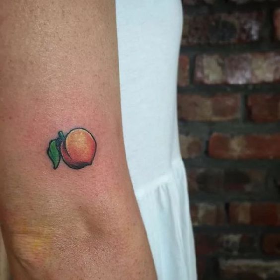 Small peach tattoo on the arm