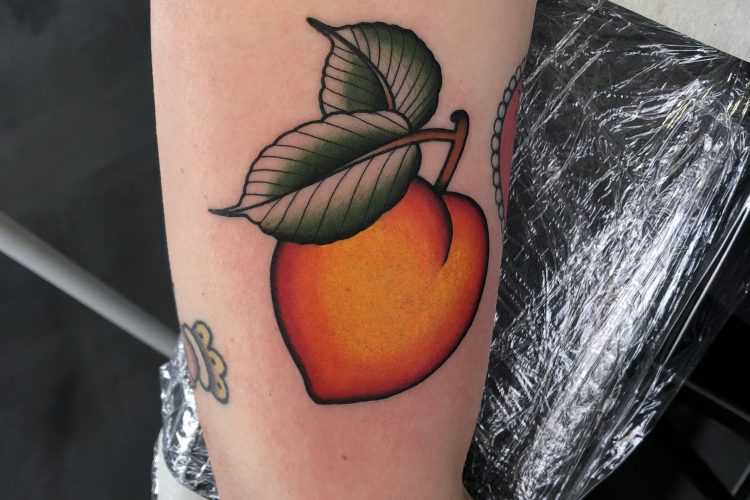 Smooth peach tattoo on the left bicep
