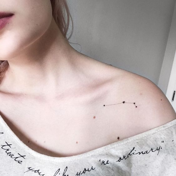 Tiny black aries constellation tattoo on the left shoulder