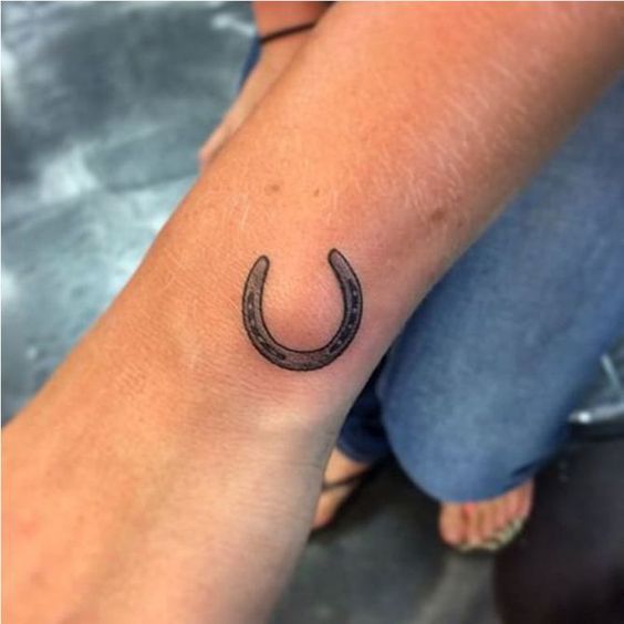 Tiny horseshoe tattoo on the wrist