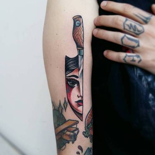 Traditional knife tattoo with a reflection of a girl face