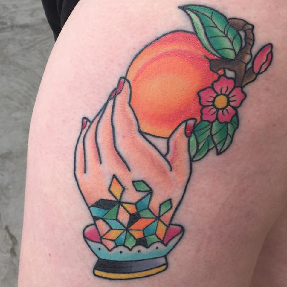 Traditional style tattoo of a hand holding a peach