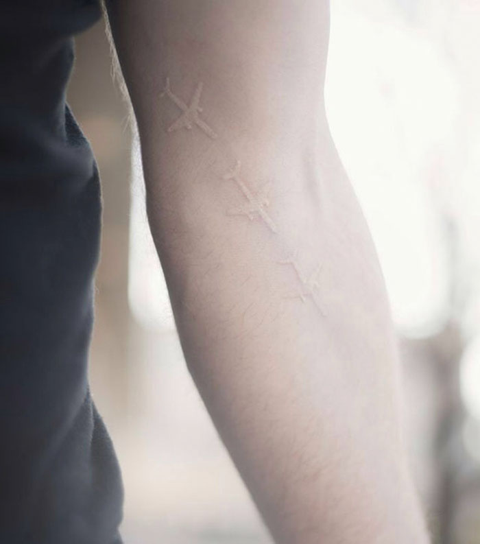 Triple white airplane tattoo on the arm