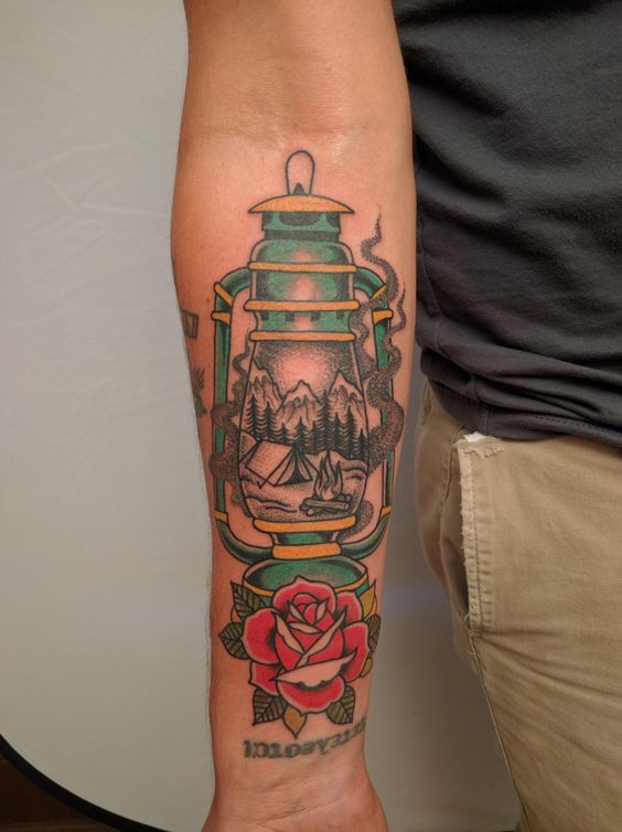 Vintage lantern tattoo with a camping landscape and a rose below