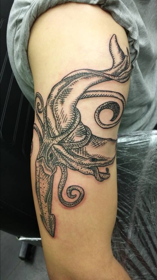 Woodcut style tattoo of a squid wrapped around the whale