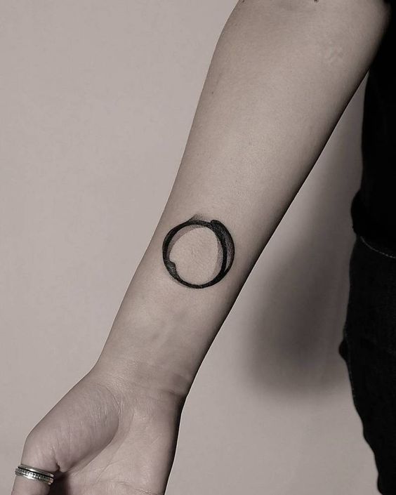 Abstract black circle tattoo on the right wrist