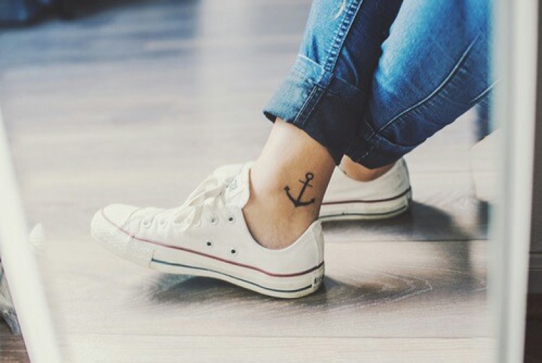Black anchor tattoo on the right inner ankle