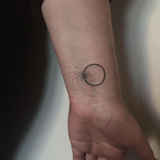 Black circle tattoo with a cloud of dots