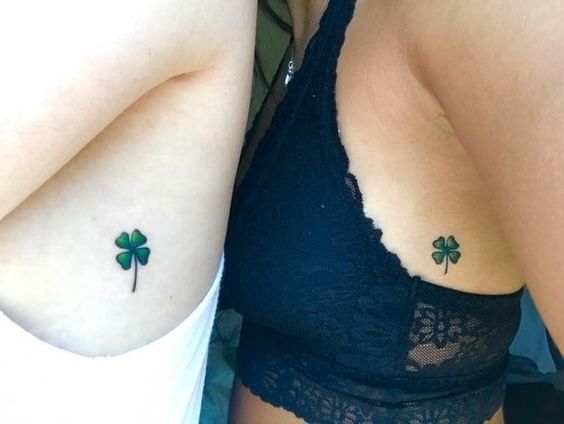 Clover tattoos on rib cages for sisters