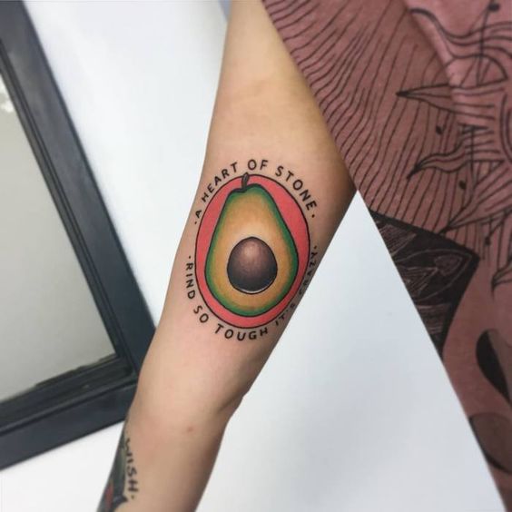 Colorful avocado tattoo on the right upper arm