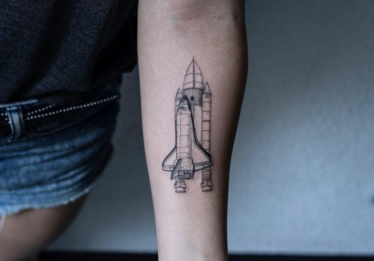 Linear space shuttle tattoo on the inner forearm