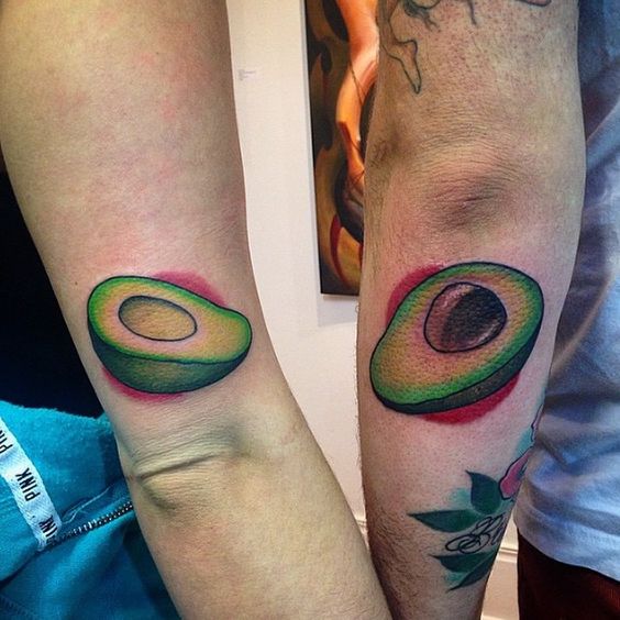 Matching neo traditional avocado tattoos on the arms. 