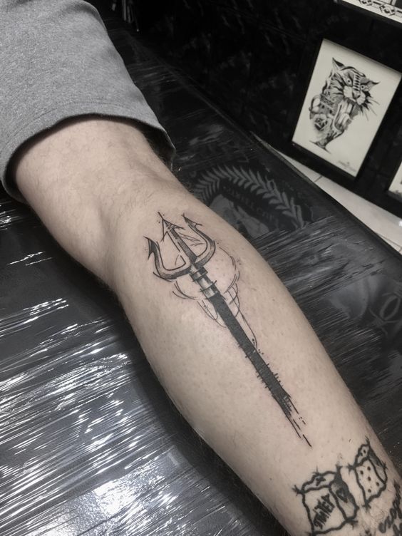 Poseidons trident tattoo on the left calf