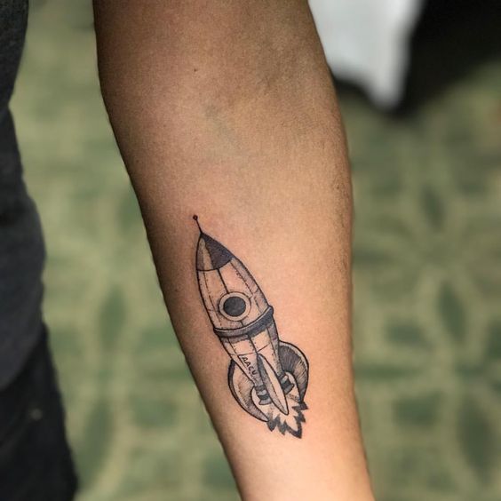 Small black spaceship on the forearm