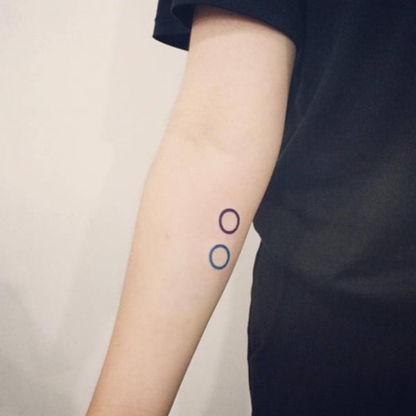 Two circle tattoos on the forearm
