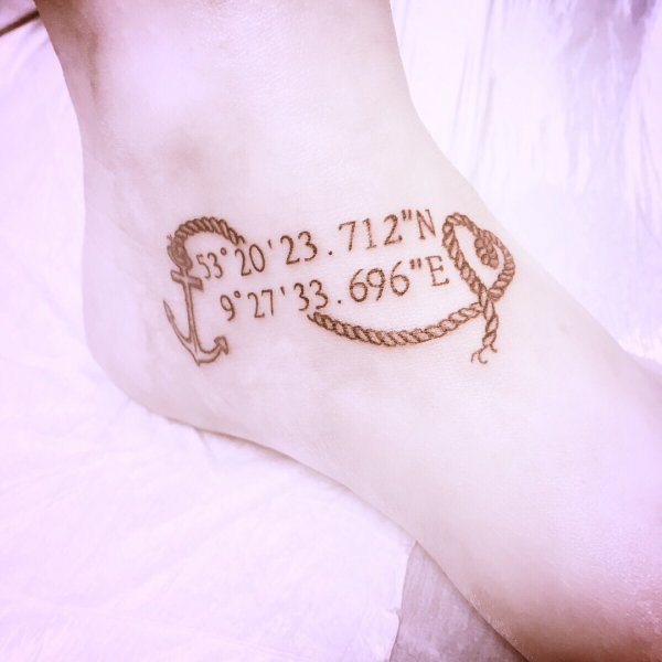 Coordinates tattoo on the foot with a rope and an anchor