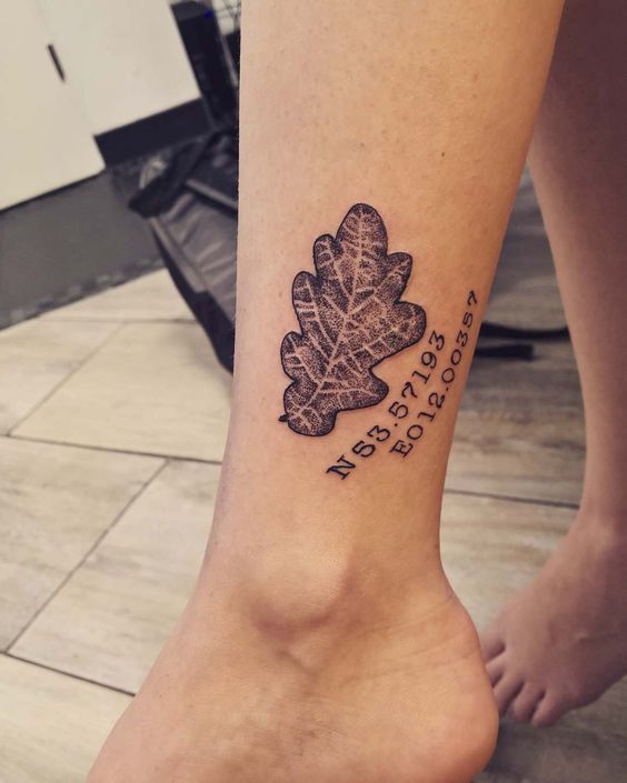 Oak leaf and coordinates tattoo on the ankle