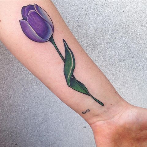 Purple tulip tattoo on the left inner forearm