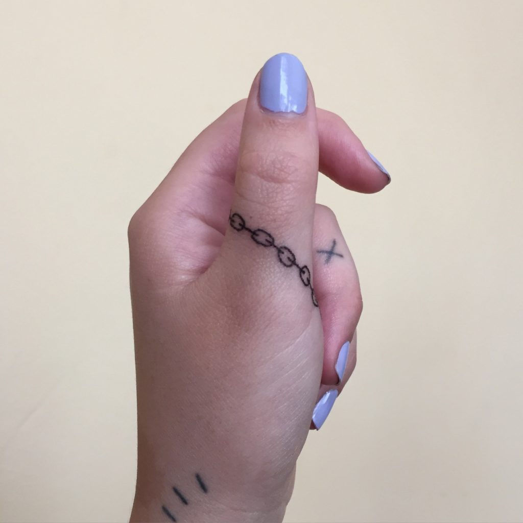 Small chain tattoo on the thumb