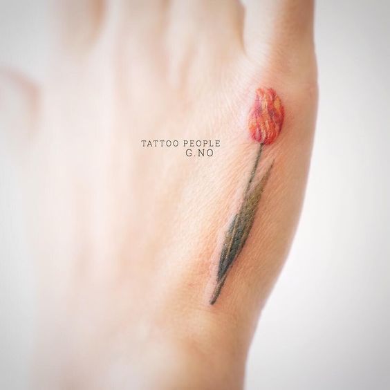 Small orange tulip tattoo on the hand