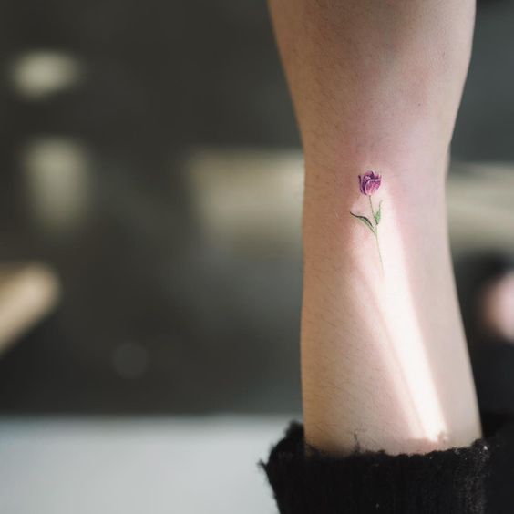 Tiny purple tulip tattoo on the right inner wrist