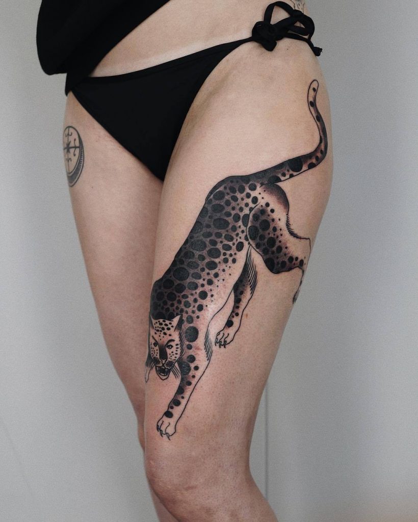 Black and grey leopard tattoo on the left thigh