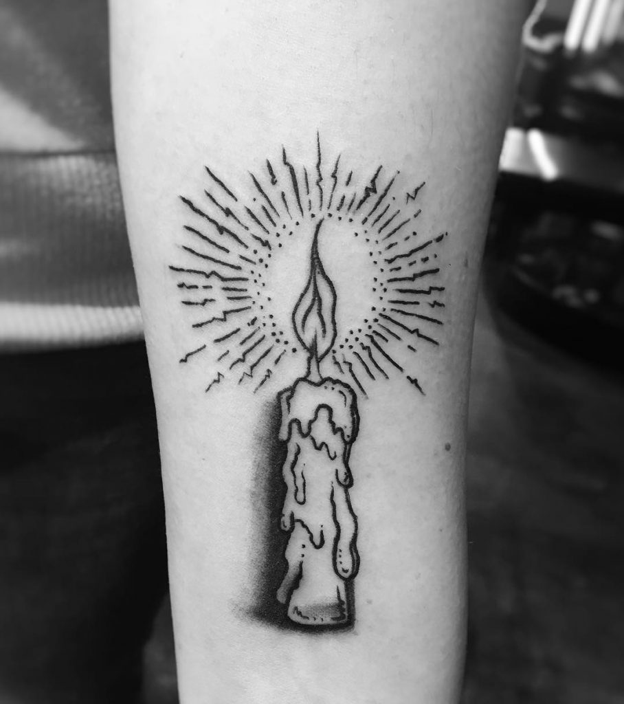 Black candle tattoo on the inner forearm by Wrenn Grey
