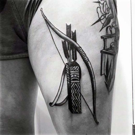 Bow with bolts tattoo on the left upper thigh