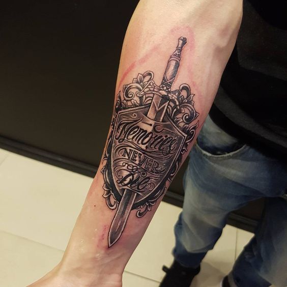 Shield and sword tattoo with a quote memories never die