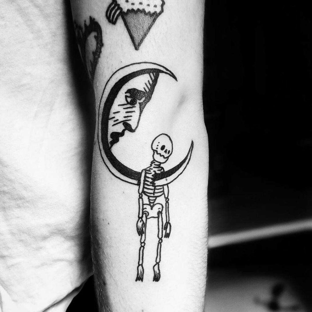 Skeleton hanging on a moon tattoo