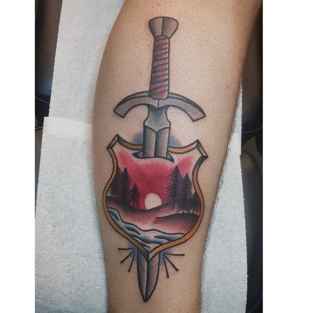 Sword and shield scenery tattoo by brett el