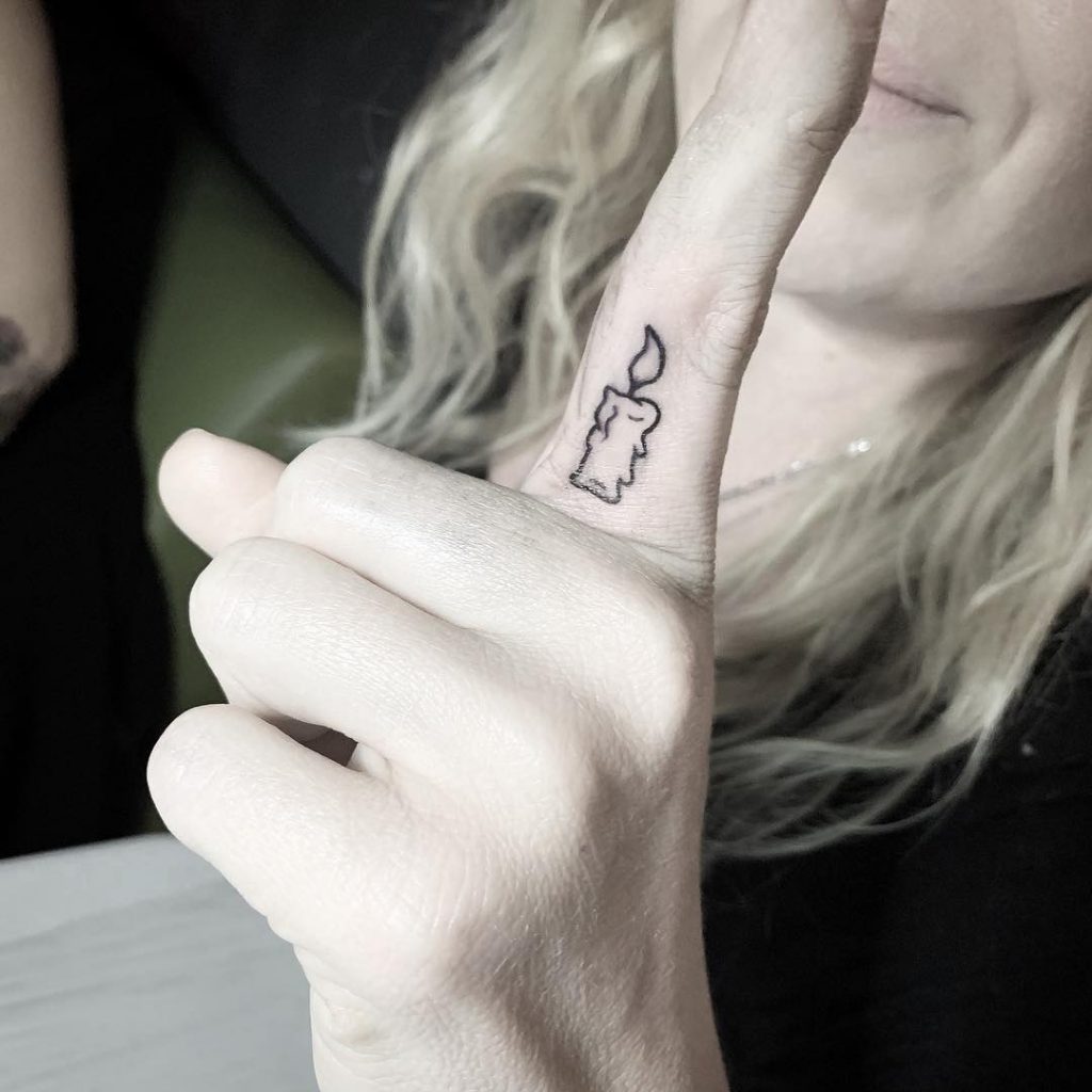 Tiny candle tattoo on the index finger