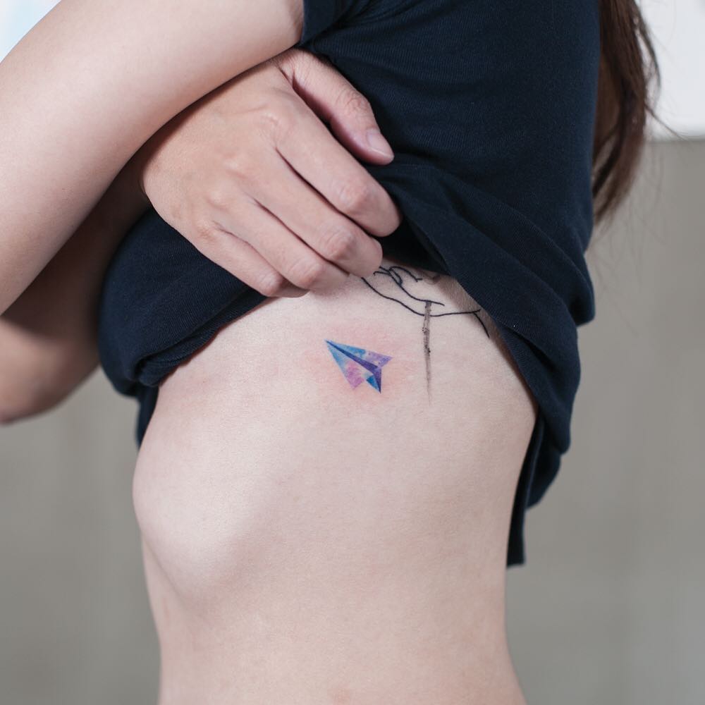 Watercolor paper plane on the rib cage